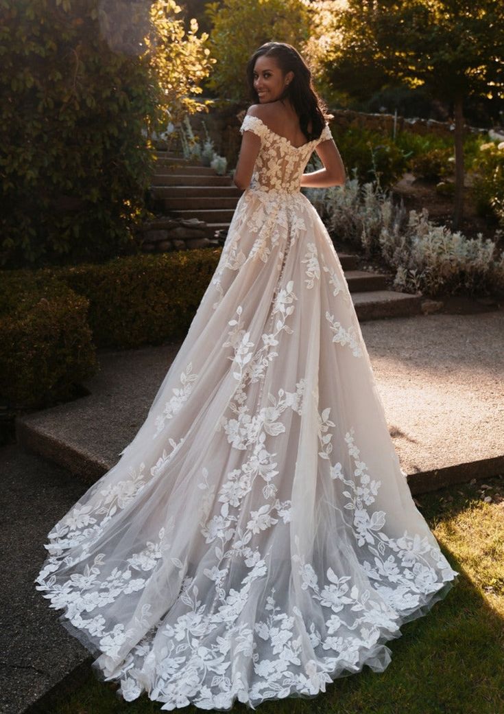 a woman in a wedding dress standing on some steps