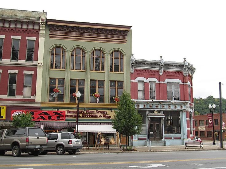 an old building with many windows on the side of it and cars parked in front