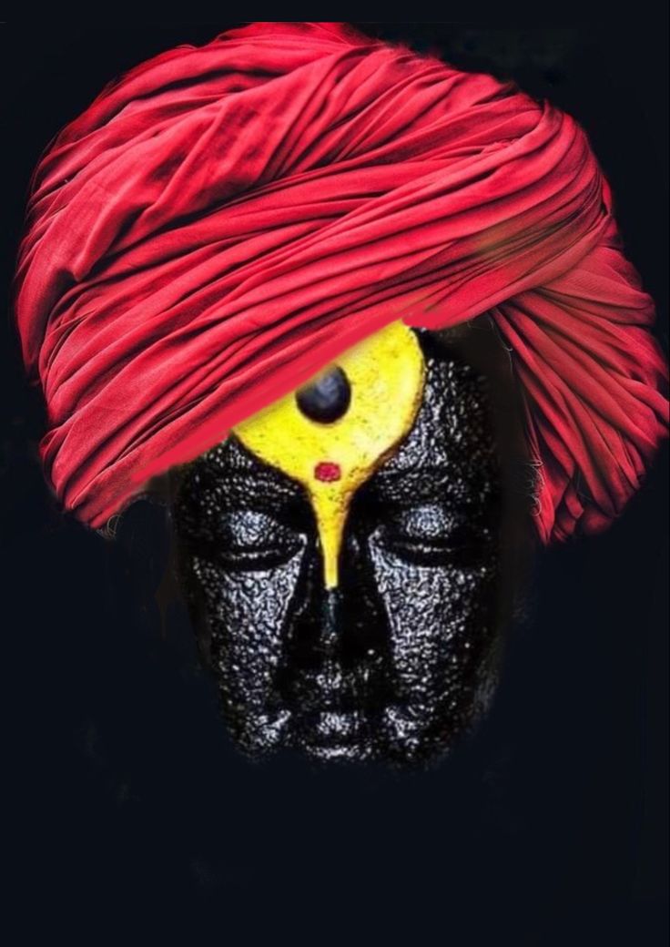 a man's face covered in black and yellow paint with a red turban