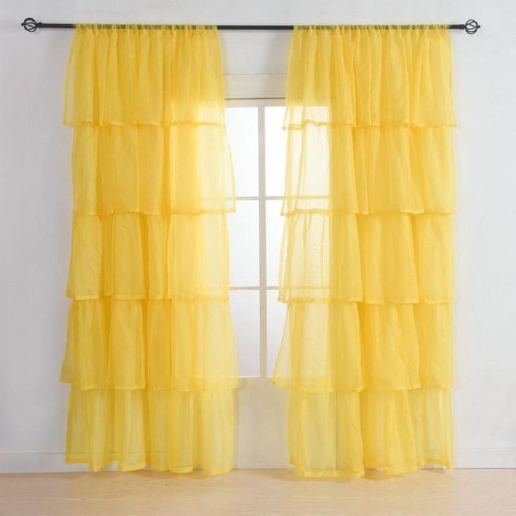 a yellow curtain hanging on the side of a window