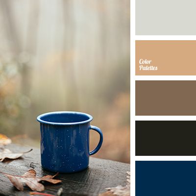 a blue coffee cup sitting on top of a wooden table next to leaves and autumn colors