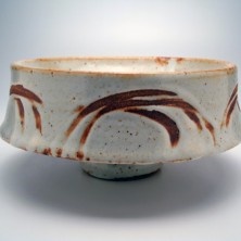 a white bowl with brown designs on it