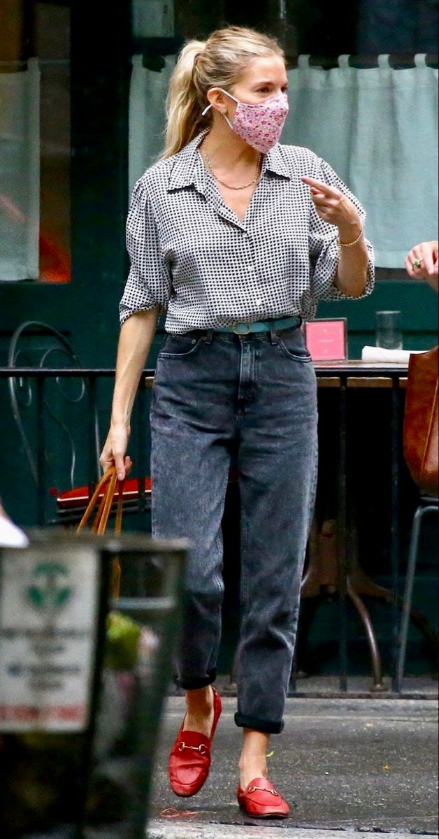 a woman walking down the street wearing a face mask