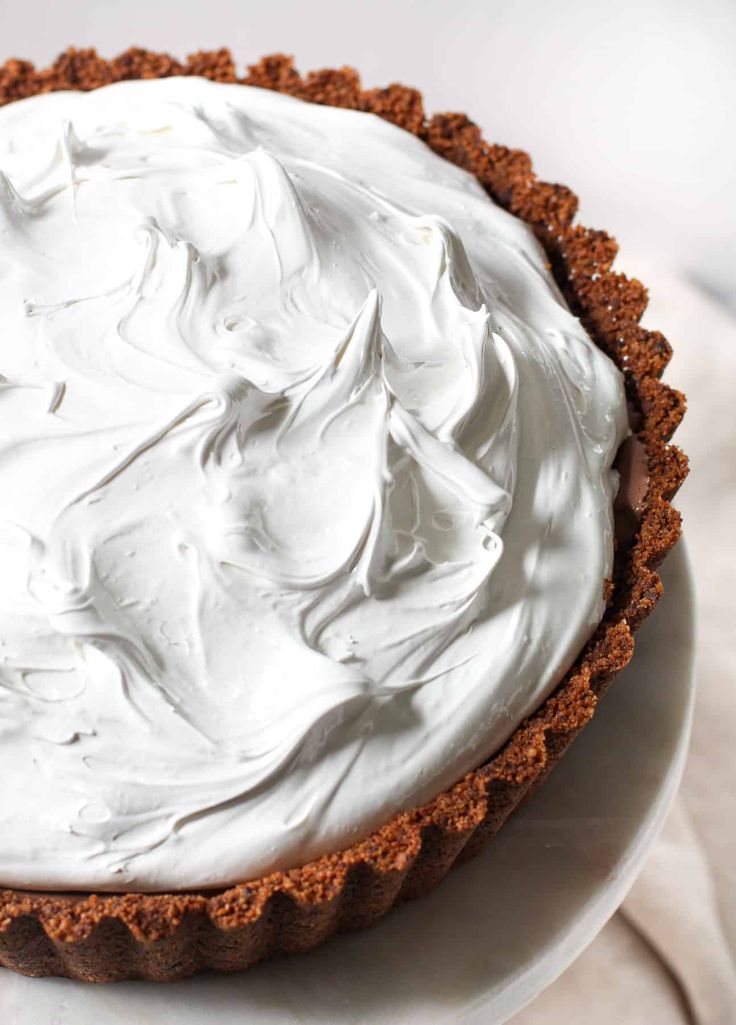 a close up of a pie on a plate with the words meringue in front of it