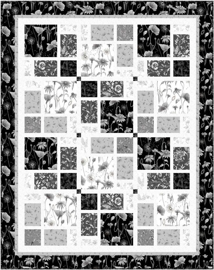 a black and white quilt with flowers on it's sides, all in squares