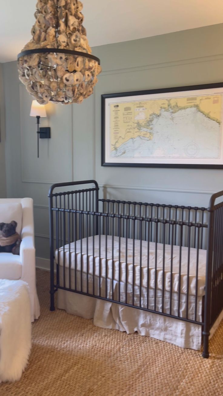 a baby crib in a room with a chandelier hanging from the ceiling