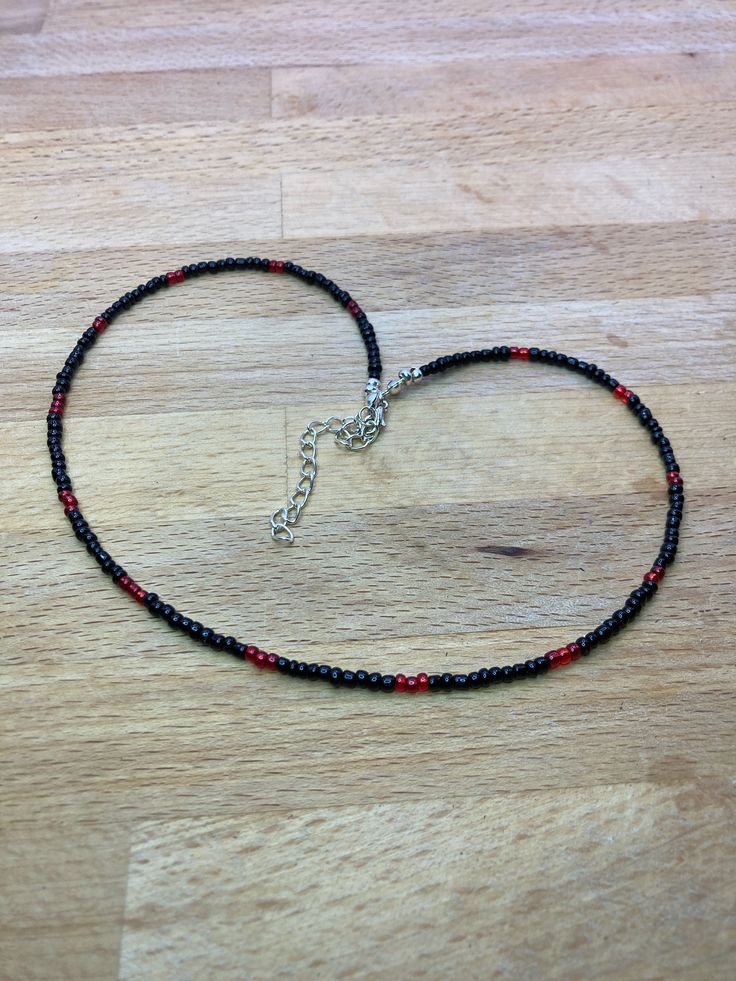 An elegant handmade Red and black seed bead necklace The beads are threaded on a strong bead stringing wire, finished with a lobster clasp. The necklace is 42 cm long or just under 16 Inches with a chain extender allowing up to 48cm All items are packaged using recyclable materials where possible to ensure they are protected in transit.  Multiple items will be packed together unless you require separate packaging, for instance, if you are gifting the items.  Please leave me a message if you requ Black Beaded Necklaces With Lobster Clasp, Adjustable Red Beaded Necklace With Black Beads, Adjustable Red And Black Beaded Necklace, Adjustable Red Necklace With Black Beads, Black Tiny Beads Choker Necklace, Red Beaded Necklaces, Recyclable Materials, Black Seed, Chain Extenders