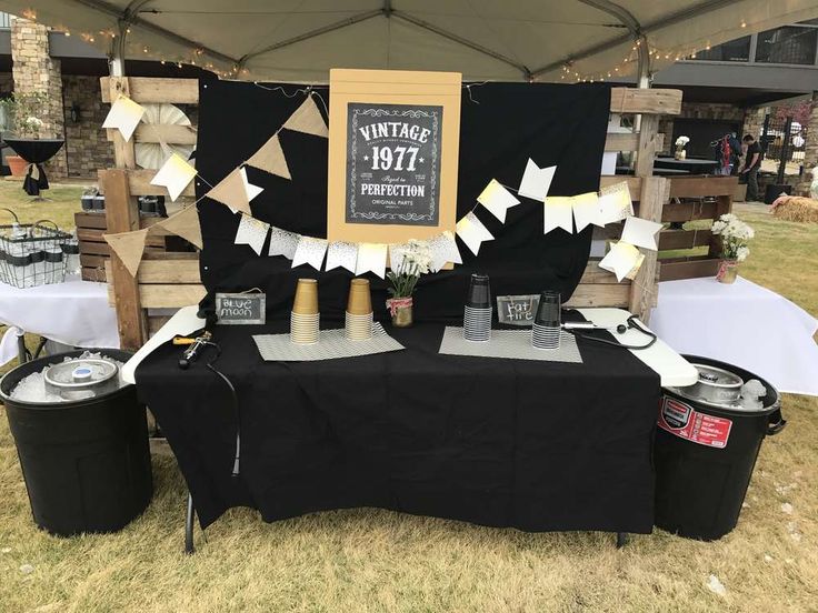 a table topped with lots of black and white items under a tent covered in paper