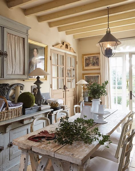 an image of a dining room setting with flowers on the table and chairs in front of it