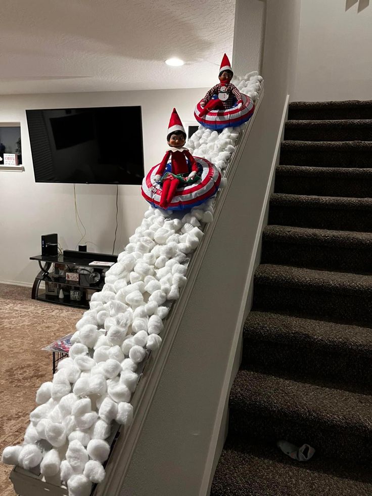 two elfs are riding in their sled down the stairs with cotton balls all over them