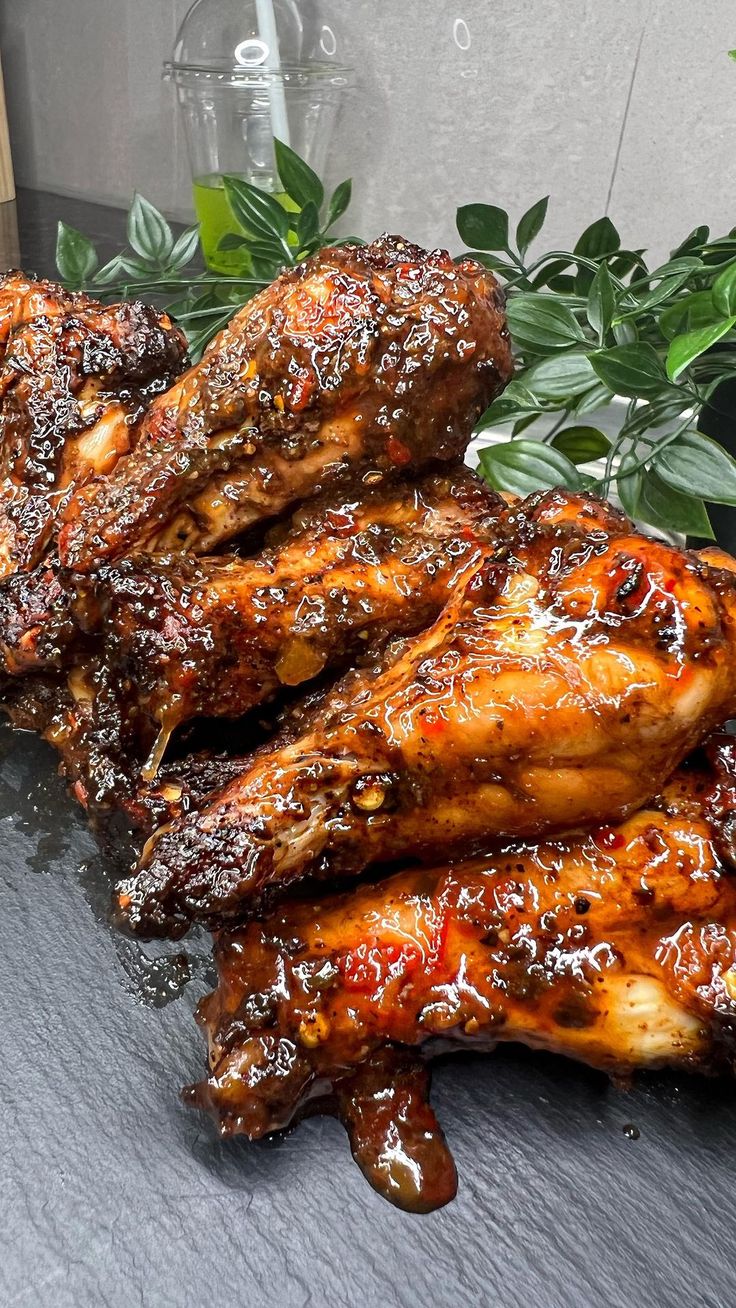 grilled chicken wings sitting on top of a table next to a potted plant