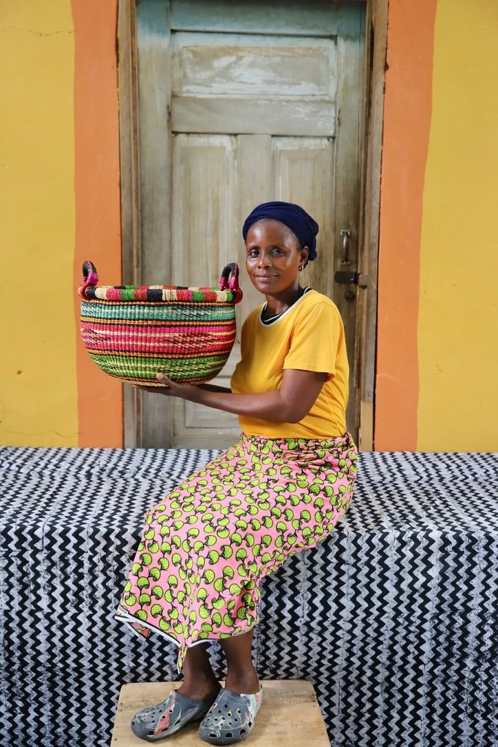 a woman sitting on a bench holding a basket