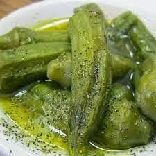 green pickles in oil on a white plate