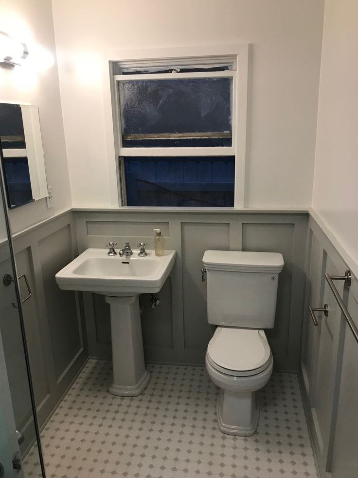 a white toilet sitting next to a sink in a bathroom