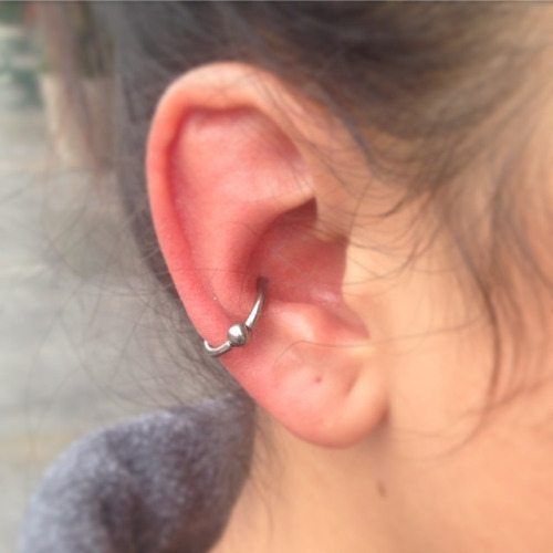 a close up of a person's ear with a small nose ring on it