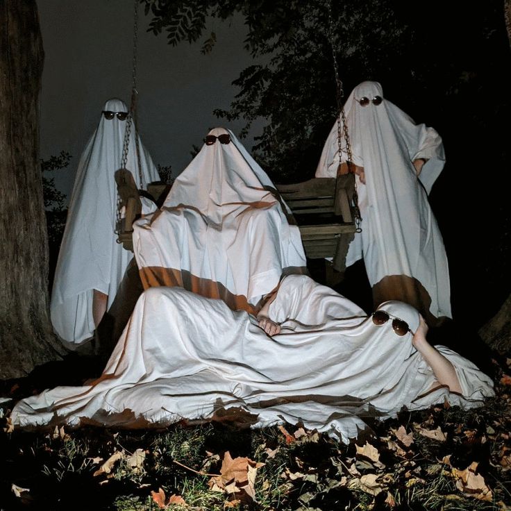 three ghostly people laying on the ground in white cloths