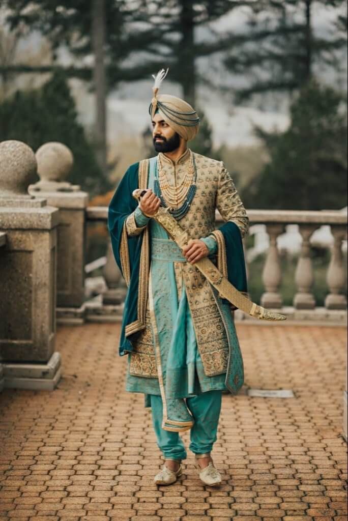 a man dressed in blue and gold is walking down the street with his hand on his hip