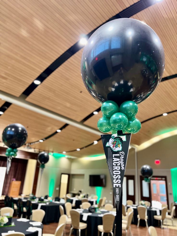 an event room with black and green balloons