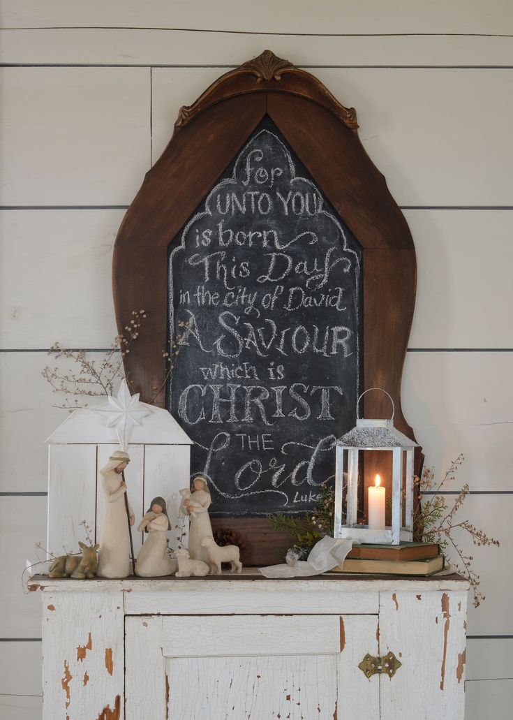 a chalkboard sign on top of an old cabinet with candles and other decorations around it