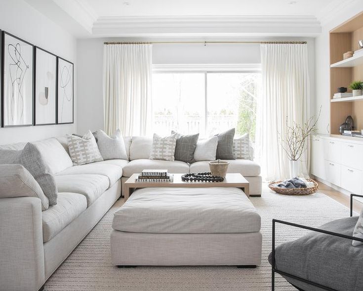 a living room filled with furniture and a large white couch in front of a window