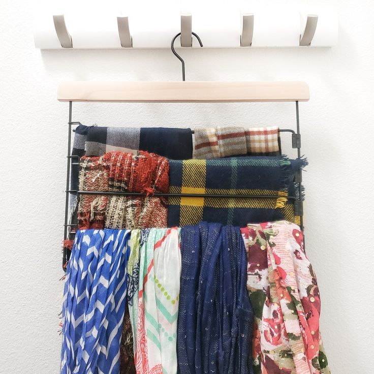 there are many scarves hanging on the rack