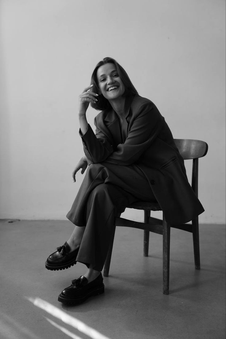 a woman sitting in a chair talking on a cell phone