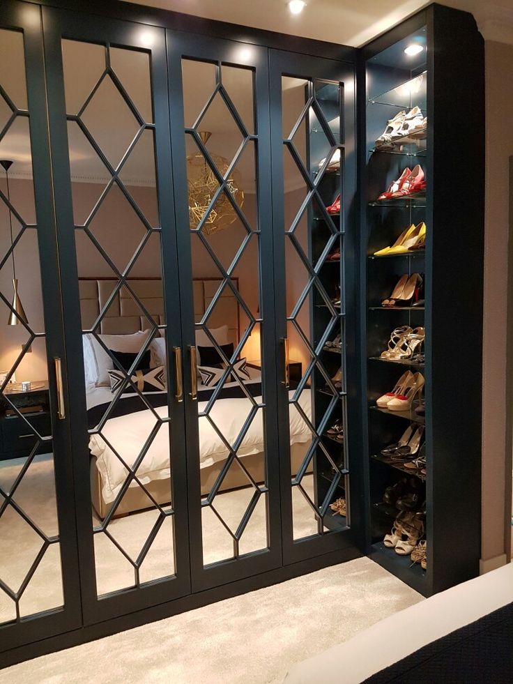 a closet with mirrored doors and shoes in it