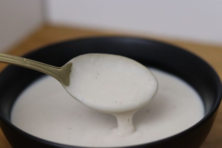 a spoon full of yogurt in a black bowl