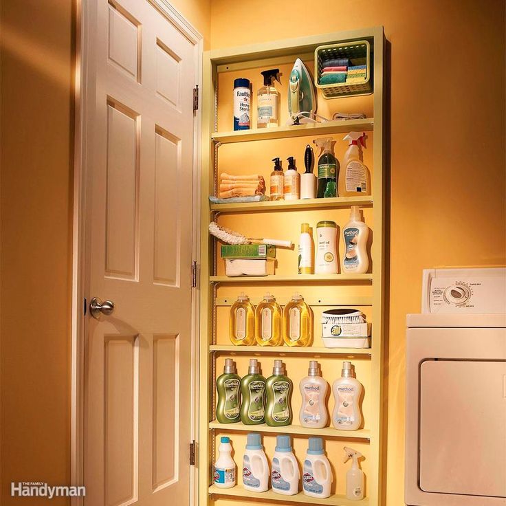 an open door leading to a bathroom with lots of cleaning products on the shelves next to the washer and dryer