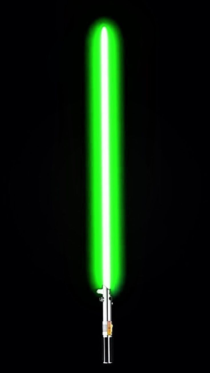 a green light saber is lit up in the dark