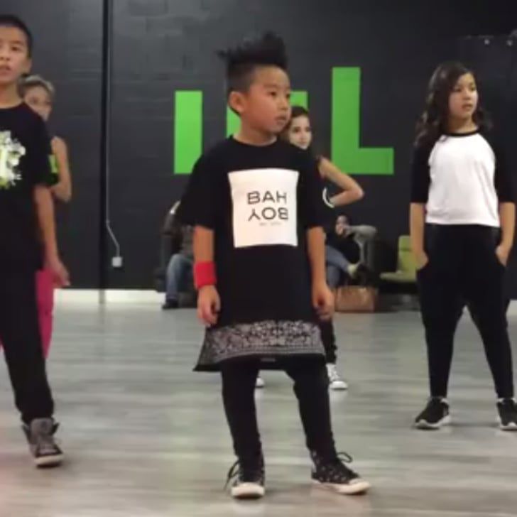 young children in black and white t - shirts are standing on the floor