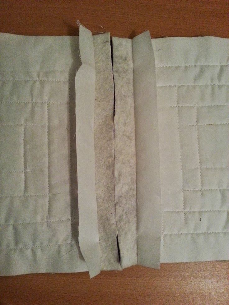 two pieces of white fabric are folded on top of each other, with one piece torn off