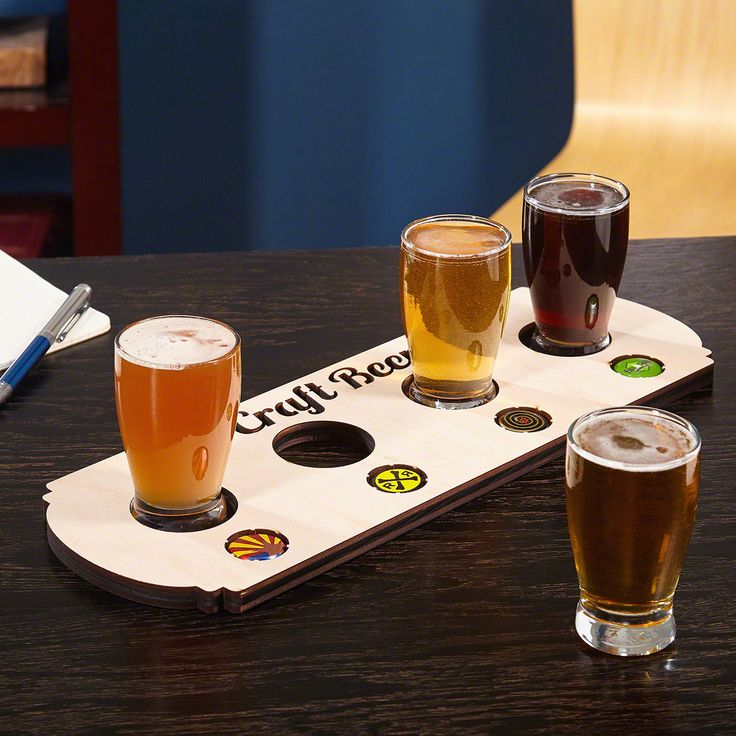 four glasses of beer are sitting on a tray