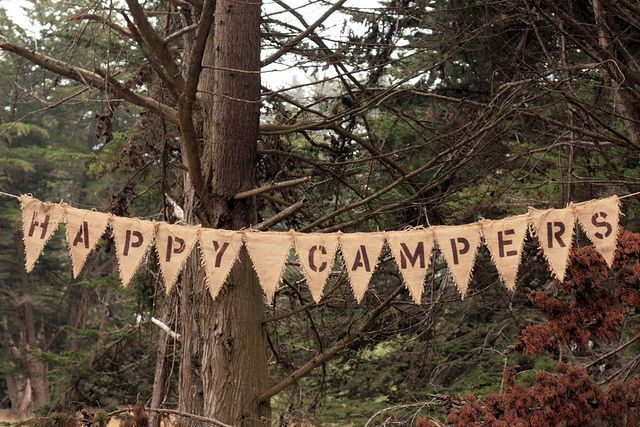 a banner that says happy campers hanging from a tree