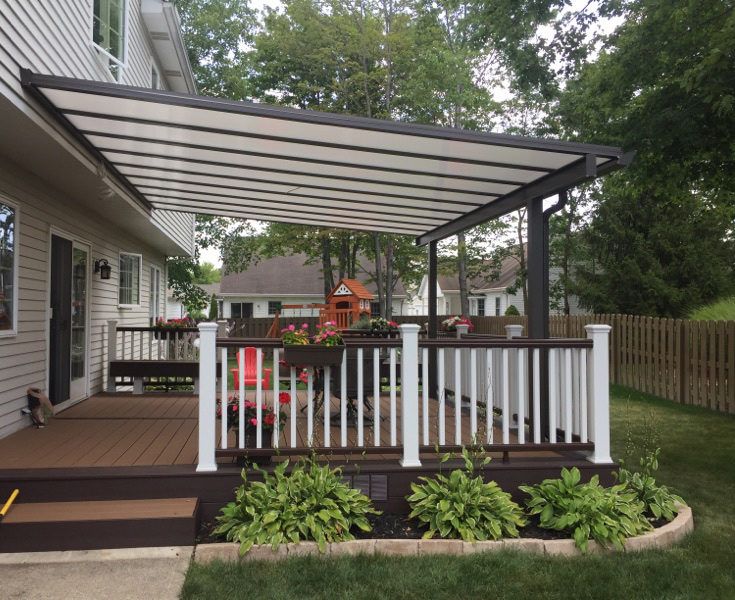 a covered deck in front of a house