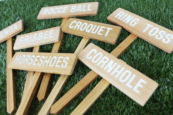 several wooden signs are placed on the grass in order to spell out names and phrases