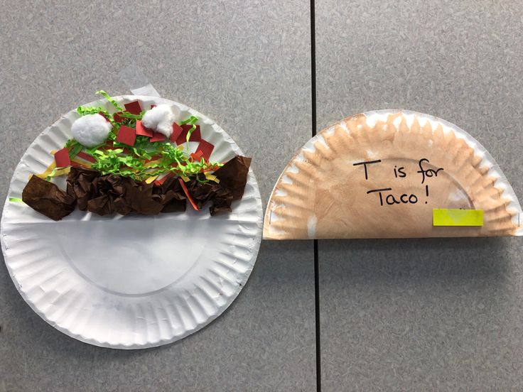 a paper plate with food on it next to a sign that says tis for taco