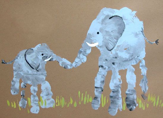 a child's drawing of an elephant and baby elephant on brown paper with grass