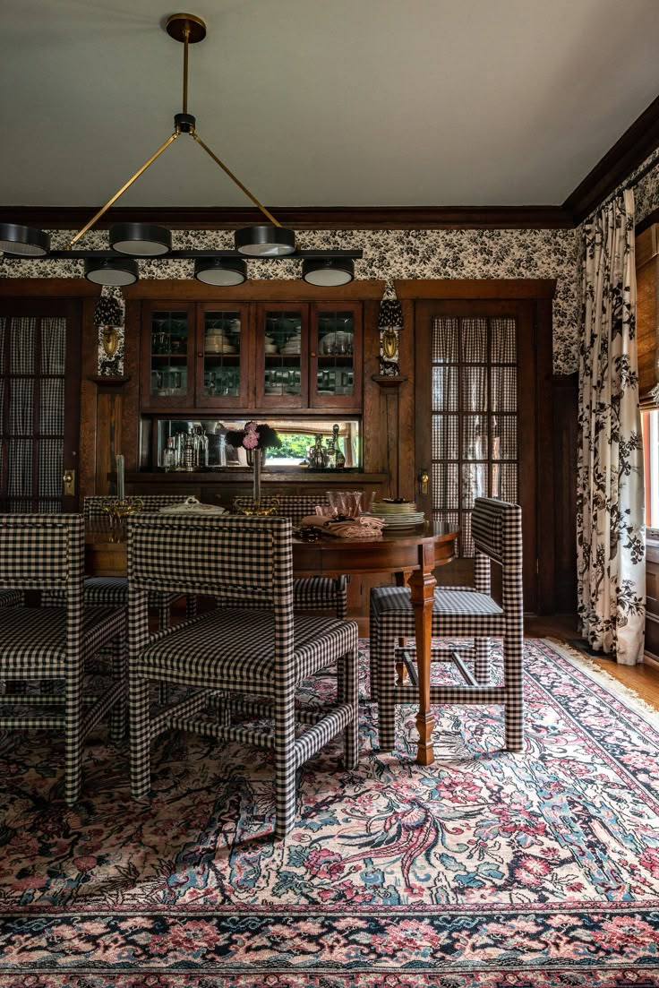 a dining room table with chairs and a rug on the floor in front of it