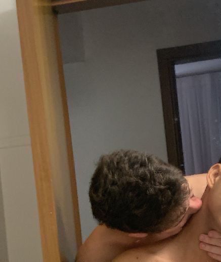 a man is getting his face massage in front of the mirror while looking at himself