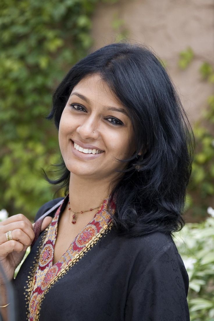 a woman is smiling while holding onto her jacket