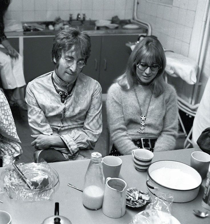 black and white photograph of three people sitting at a table with plates, cups and utensils