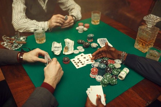 people playing cards at a table with drinks