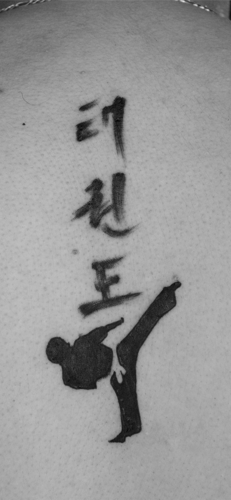 the back of a man's neck with writing on it and an image of a person doing karate