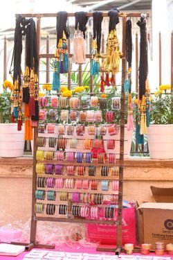 an assortment of bracelets and necklaces on display in front of a store window