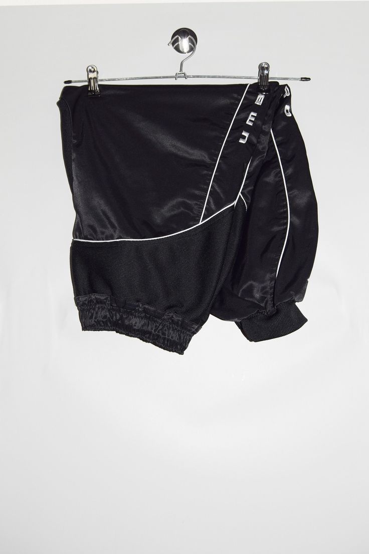 "Umbro track pants in black and side brand spell out embroidery. - Size tag: Please always check measurements before buying. Men's L-  Above ankle lenght, or Women's oversized/baggy style track pants. - Measurements (laying flat): Waist: 15\" stretches to 19\" Outleg: 33\" Inleg: 22\" Thigh: 13.5\" Rise: 13\" Leg opening: 4\"- 7.5\"  -Wear: /Please see images for details/ Good condition. Small red stain on the back as shown on the picture. - Fabric: Polyester Cotton *All of our items are preloved pieces so some signs of natural wear and age are to be expected. Please look through the photos carefully to check if the condition is to your satisfaction. *All efforts are made to show any defects however small imperfections may be missed. *We try to describe the sizes as accurately as possible, Sporty Streetwear Bottoms With Elastic Waistband, Sporty Elastic Waistband Bottoms For Streetwear, Sporty Short Pants For Streetwear, Athleisure Sweatpants For Streetwear, Athleisure Short Sweatpants For Streetwear, Athleisure Streetwear Short Sweatpants, Sporty Black Parachute Pants For Loungewear, Urban Bottoms With Elastic Side Panels For Streetwear, Streetwear Joggers With Elastic Side Panels In Black