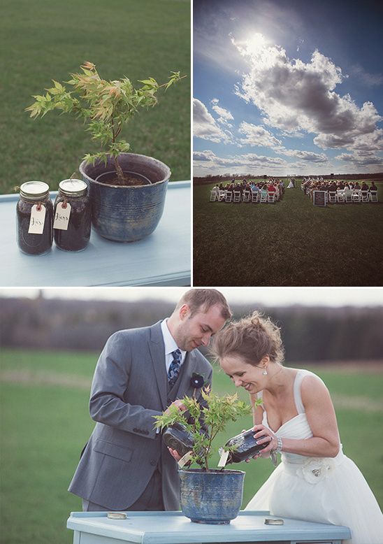 a couple standing next to each other in front of a table with plants on it