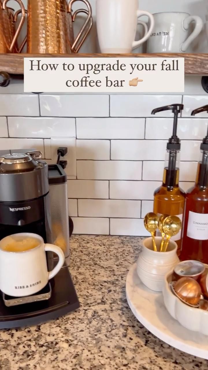 a coffee maker sitting on top of a counter next to a cup and saucer