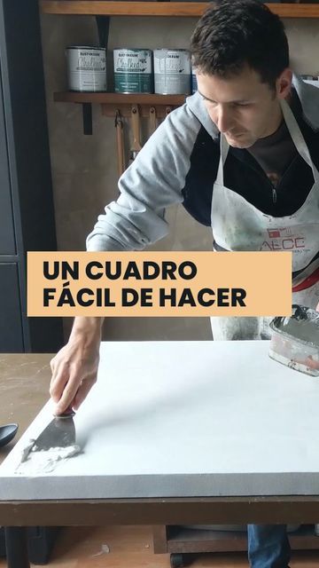 a man in an apron is working on a piece of white paper with the words un cuadro facil de hacer