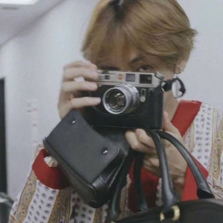 a woman holding a camera up to her face